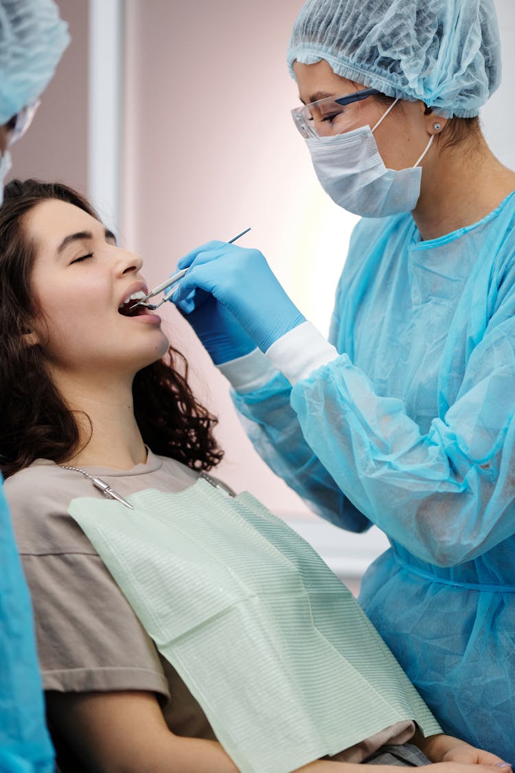 A Dentist Checking The Woman's Teeth