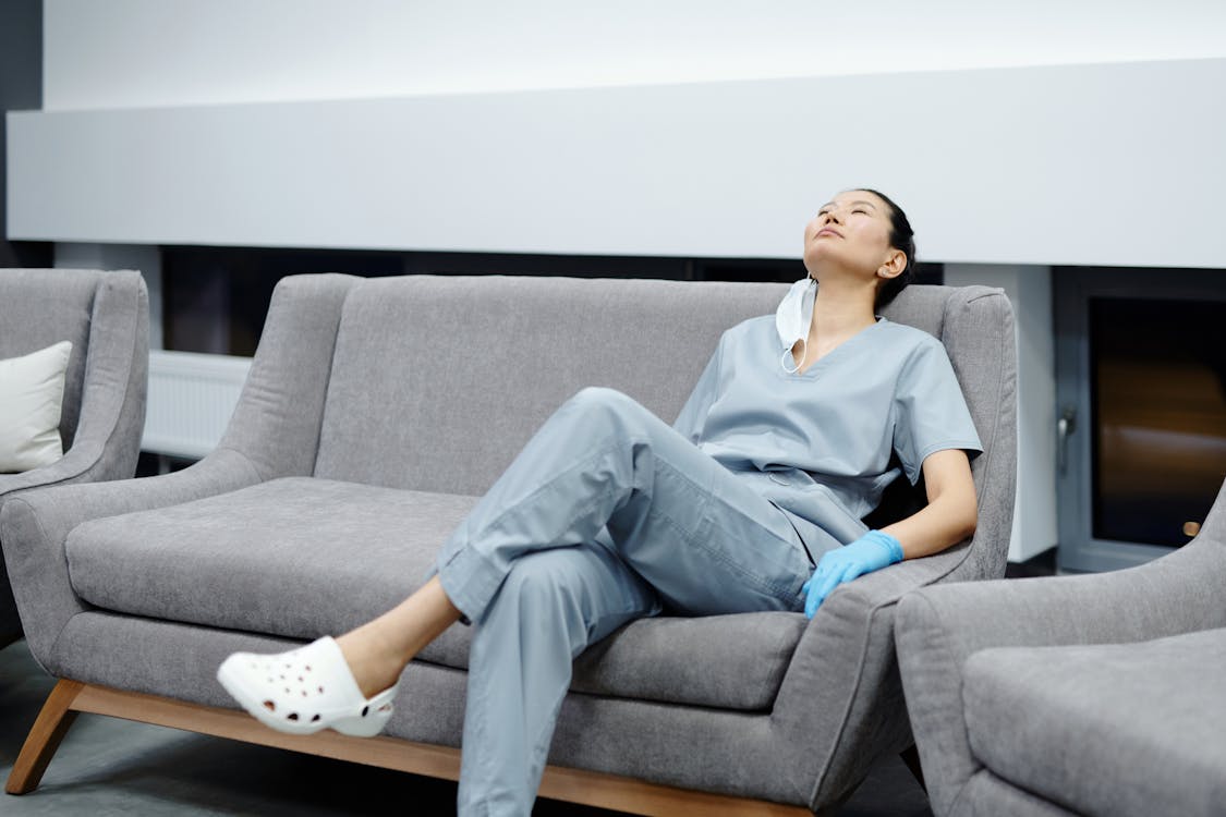 Woman in Gray Dress Sitting on Gray Couch