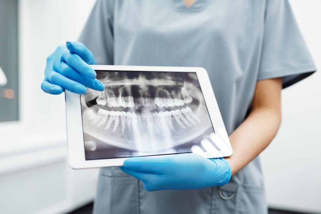 Free Person Holding White Tablet Computer with Picture of Teeth Stock Photo