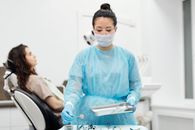 一位牙医在现代诊所里准备牙科工具的防护装备