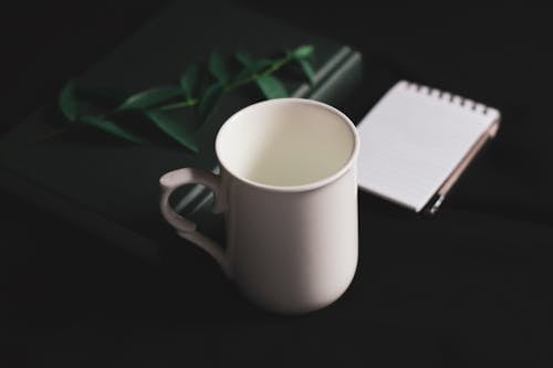 Composition of white mug and notebooks
