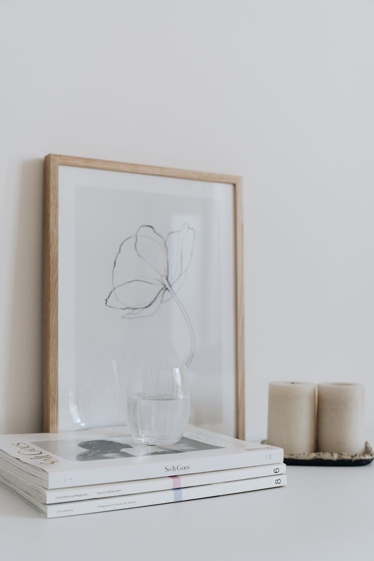 A Glass Of Water Over A Stack Of Magazines