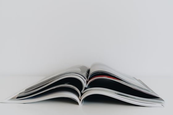 Open printed magazine on a white table — photo by alleksana on Pexels