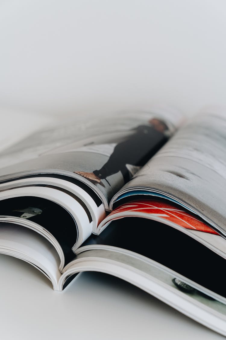 A Stack Of Open Magazines