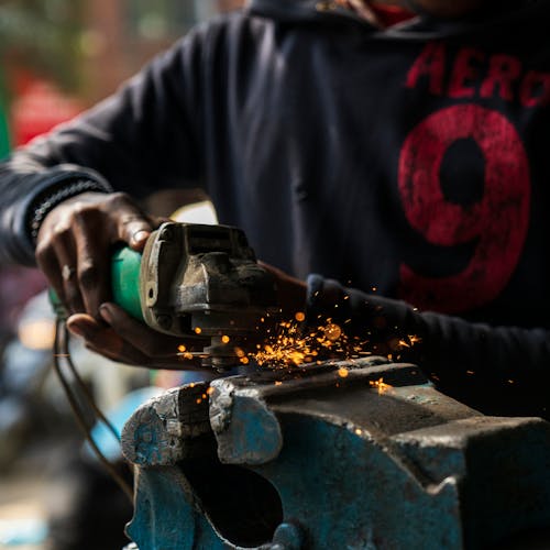 Free Crop faceless black labourer welding metal detail Stock Photo