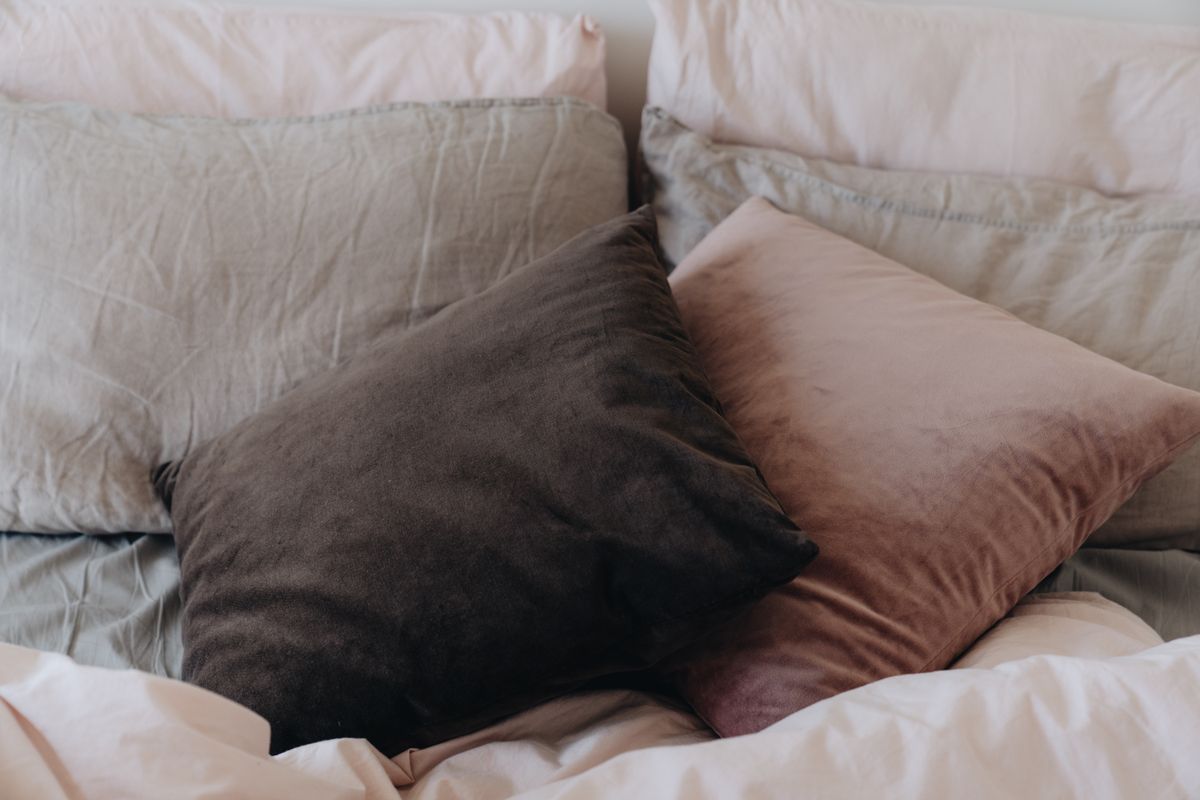 Close view of several pillows arranged on a made bed