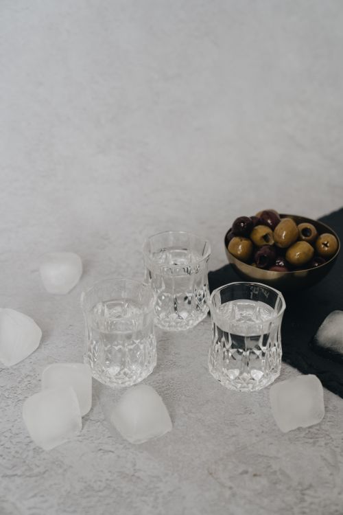 Free Three glasses with water and olives surrounded by ice cubes on a textured surface. Stock Photo