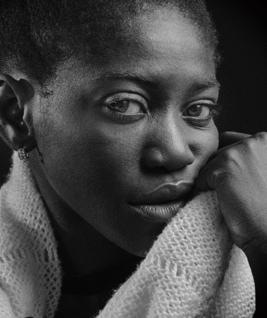 A dramatic black and white portrait capturing a woman's thoughtful expression.