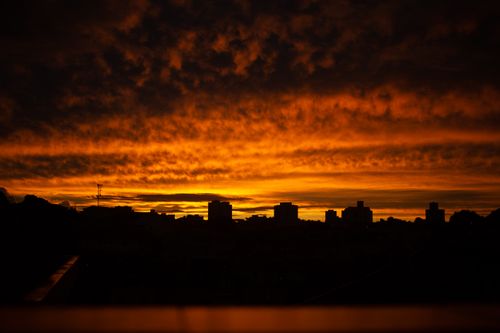Free Silhouettes of city buildings under magnificent cloudy dark sky during sundown time Stock Photo