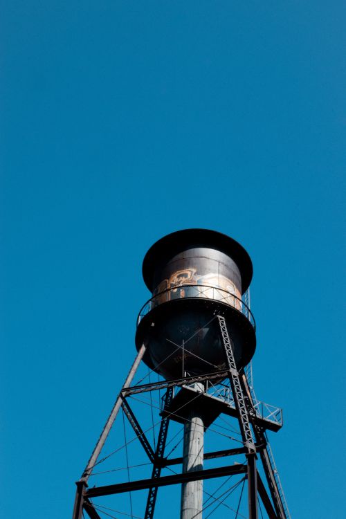 Free Water tower with steel structure under a clear blue sky in Montreal. Stock Photo