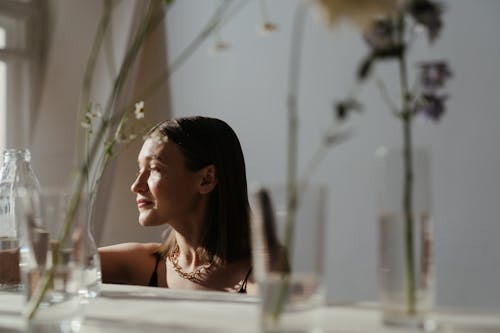 Woman in White Tank Top Sitting on White Chair