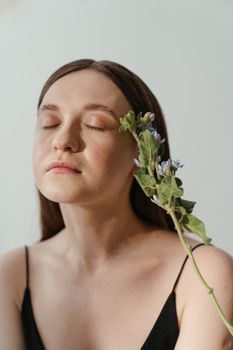 一位闭着眼睛的女性特写肖像，装饰着一朵精致的花