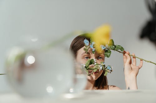 Free Woman in White Tank Top Holding Yellow Flowers Stock Photo