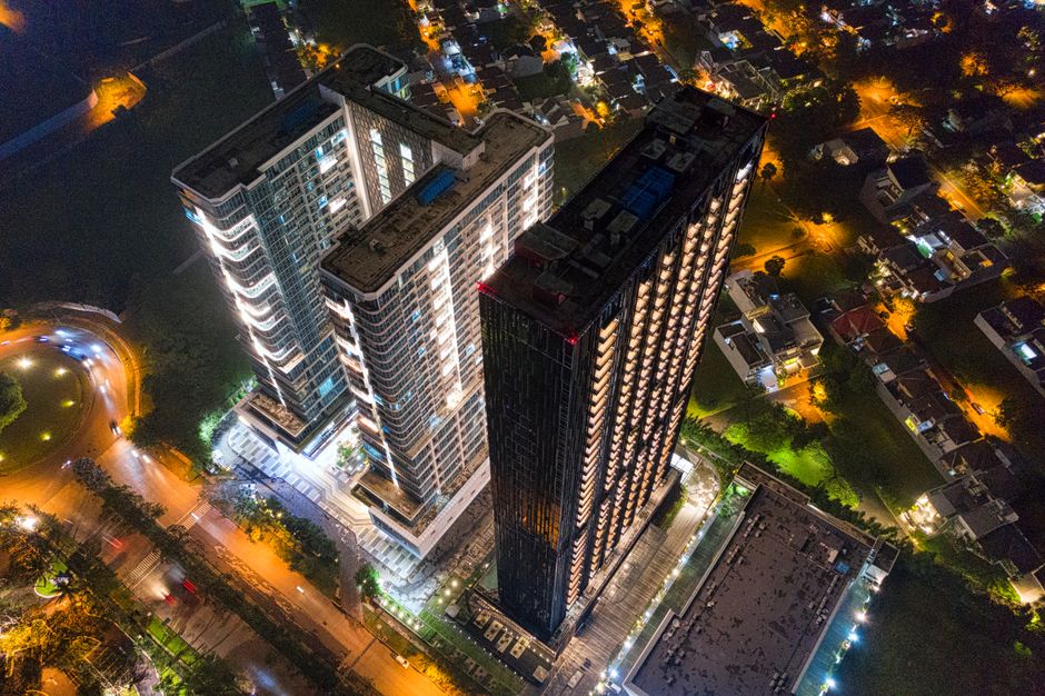 Illuminated skyscrapers in Banten, Indonesia captured from above at night with surrounding city lights.