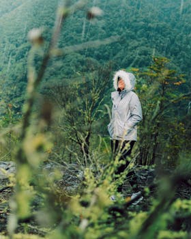 A woman enjoys a rainy hike in lush greenery of Puerto Varas, Chile.