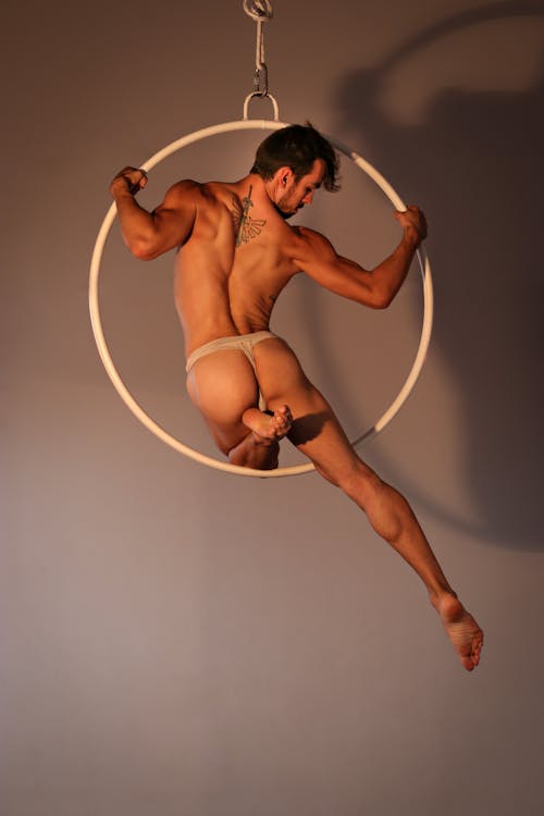 Powerful male acrobat performing on gymnastic circle