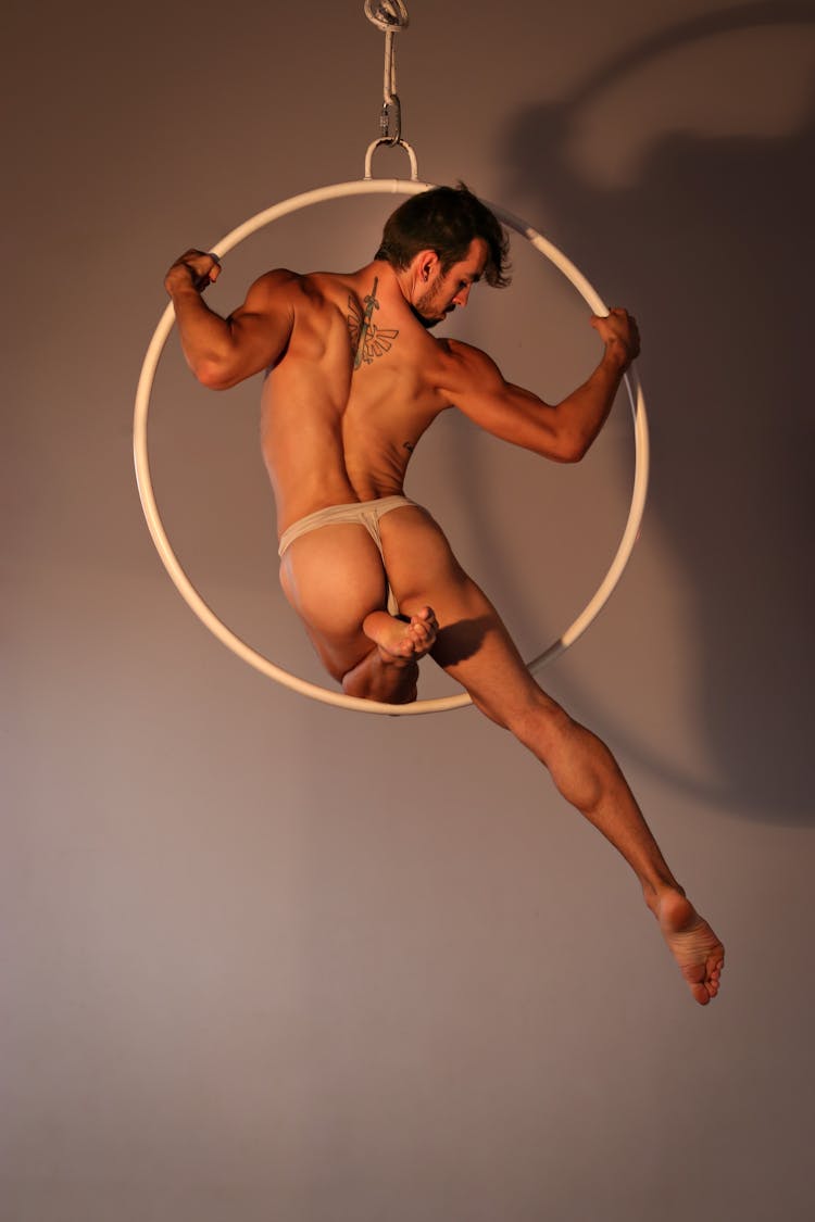 Powerful Male Acrobat Performing On Gymnastic Circle