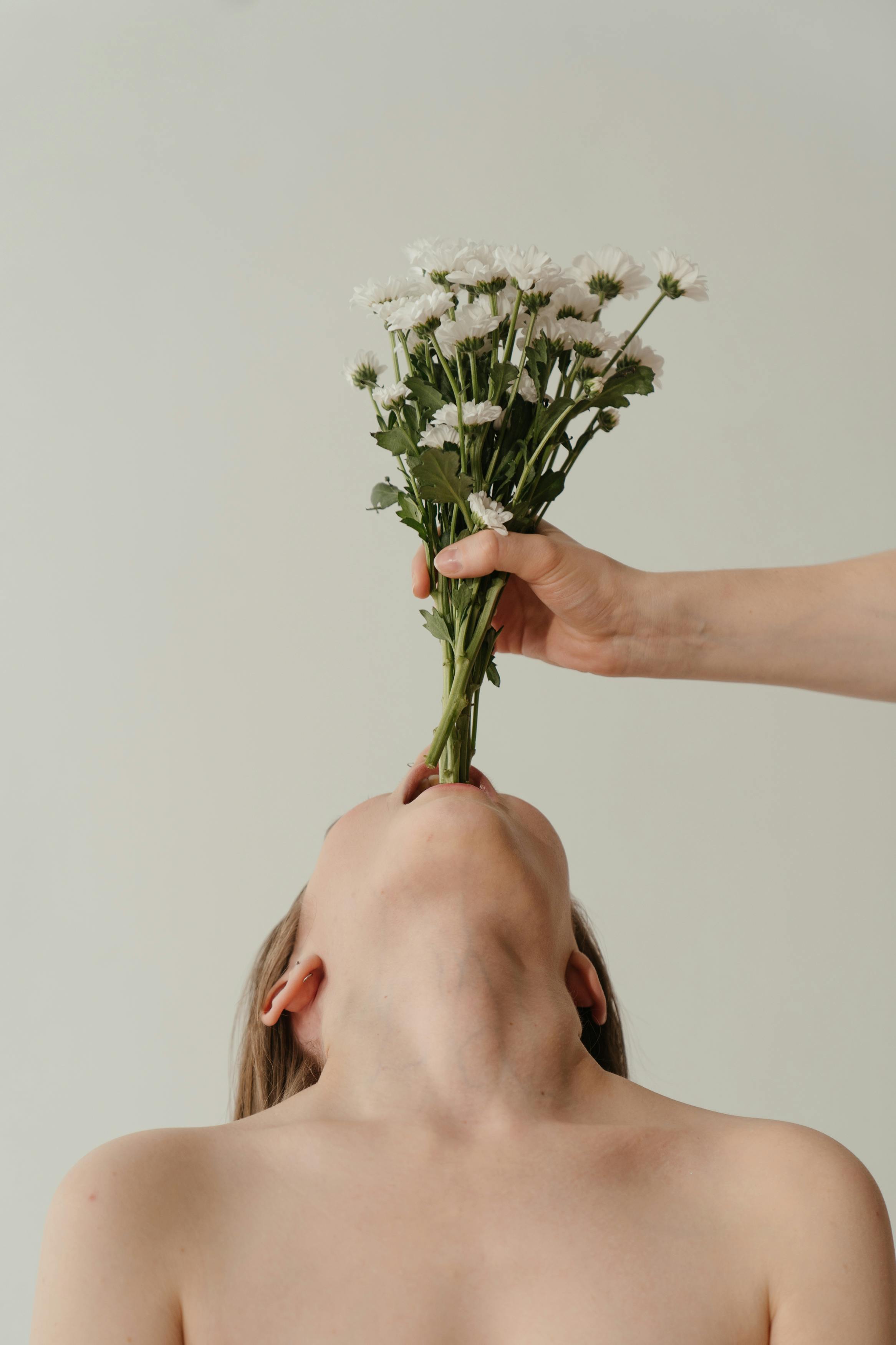 一位女人叼着菊花束的艺术肖像