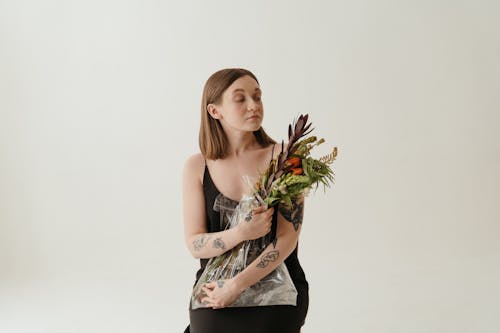 Woman in Black Tank Top Holding Green Plant