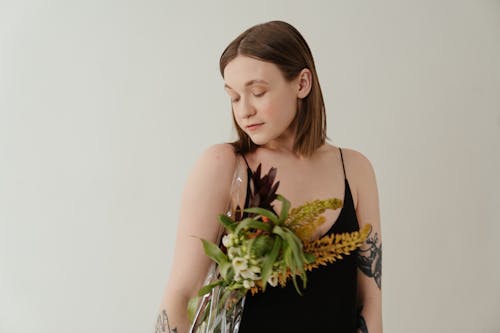 Woman in Black Tank Top Holding Green Plant