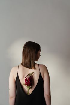 女子身着黑色露背花朵连衣裙，优雅美丽尽显