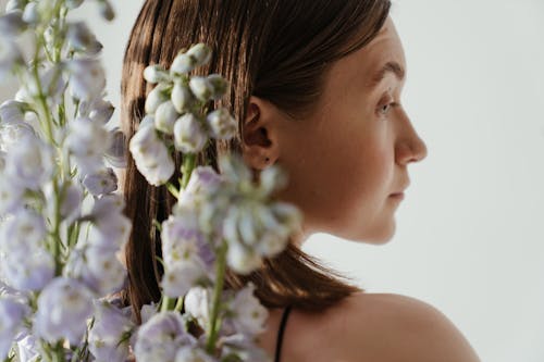 Woman With White and Purple Flowers on Her Ear