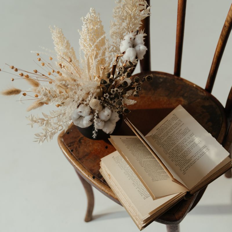 Armchair with an open book and dried flowers