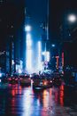 在黑夜中，汽车沿着现代城市街道的沥青路面行驶