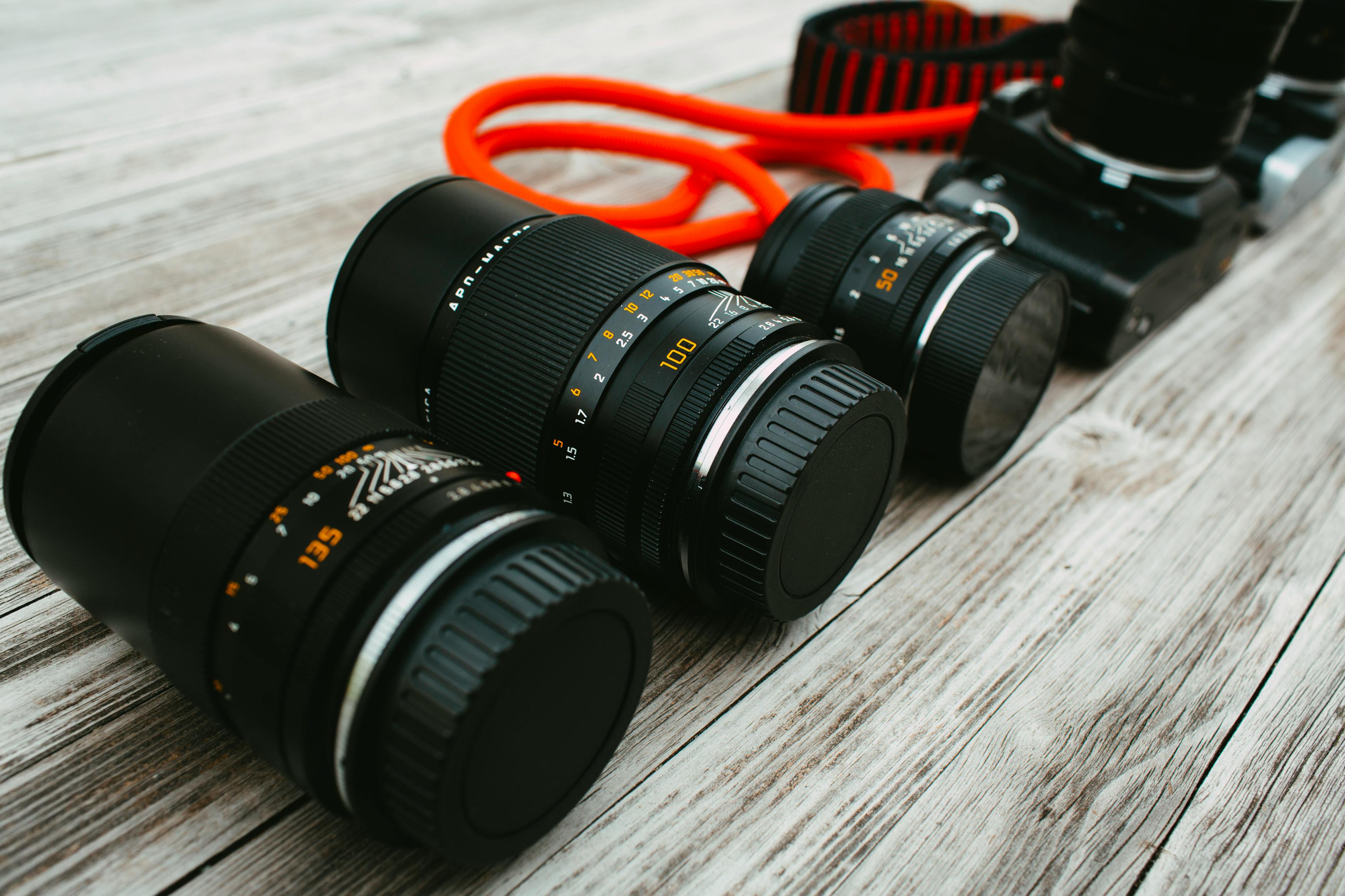 modern camera lenses placed on wooden table