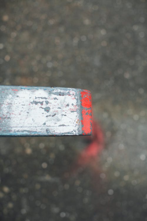 Free From above of industrial metal detail against blurred wet asphalt road in city Stock Photo