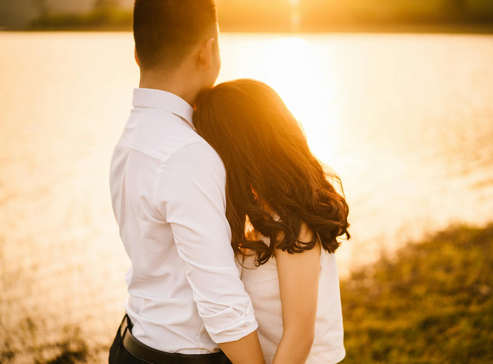 Woman hugging her husband in front of a lake. | Photo: Pexels