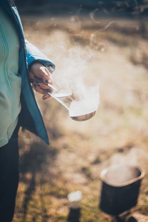 Person Holding a Ladle and Spoon