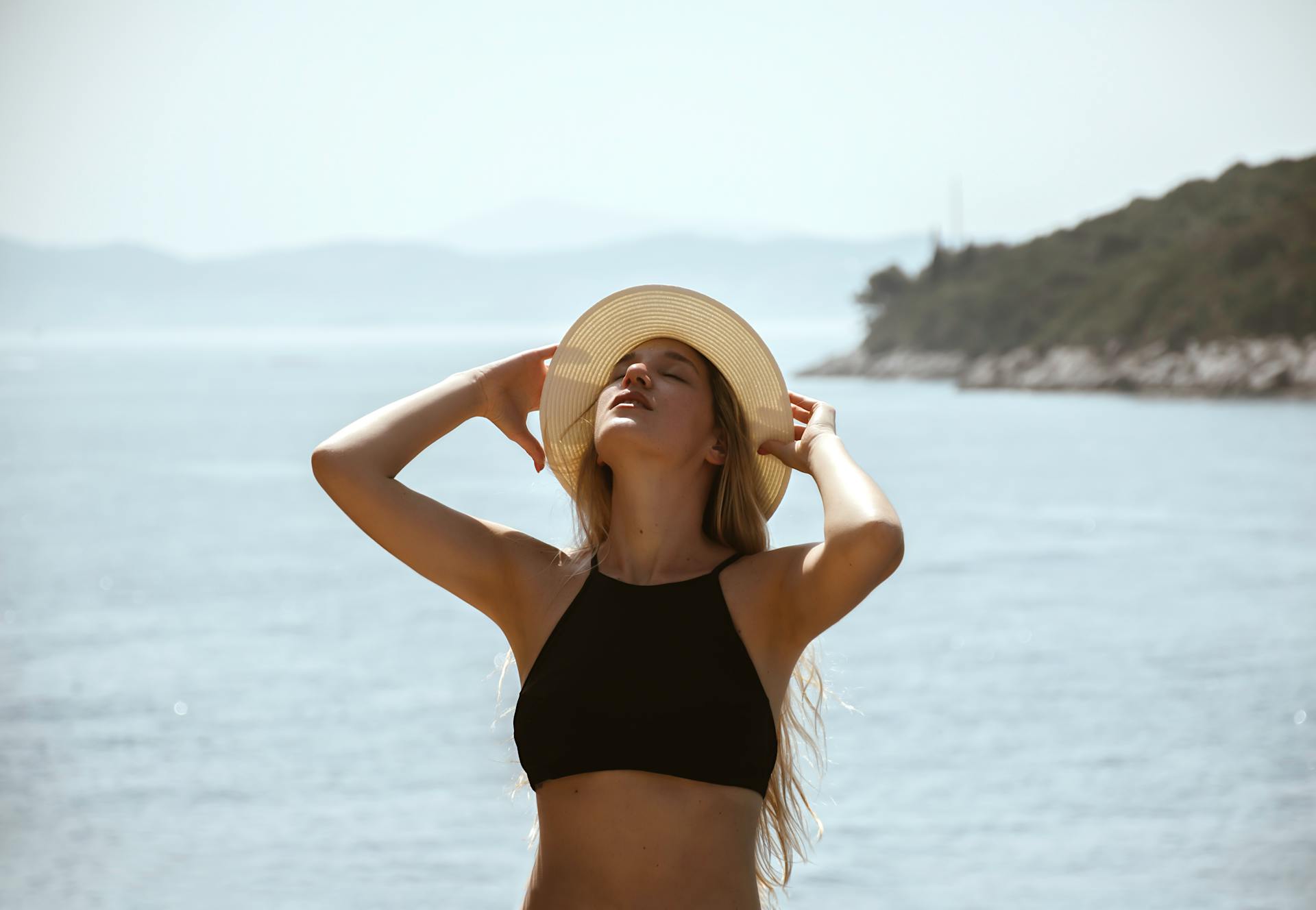 Woman in a sun hat enjoying a sunny day by the Dubrovnik coast.