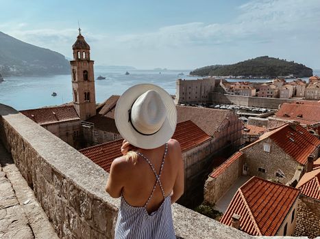 Woman Standing on a Balcony Near a Bell Tower