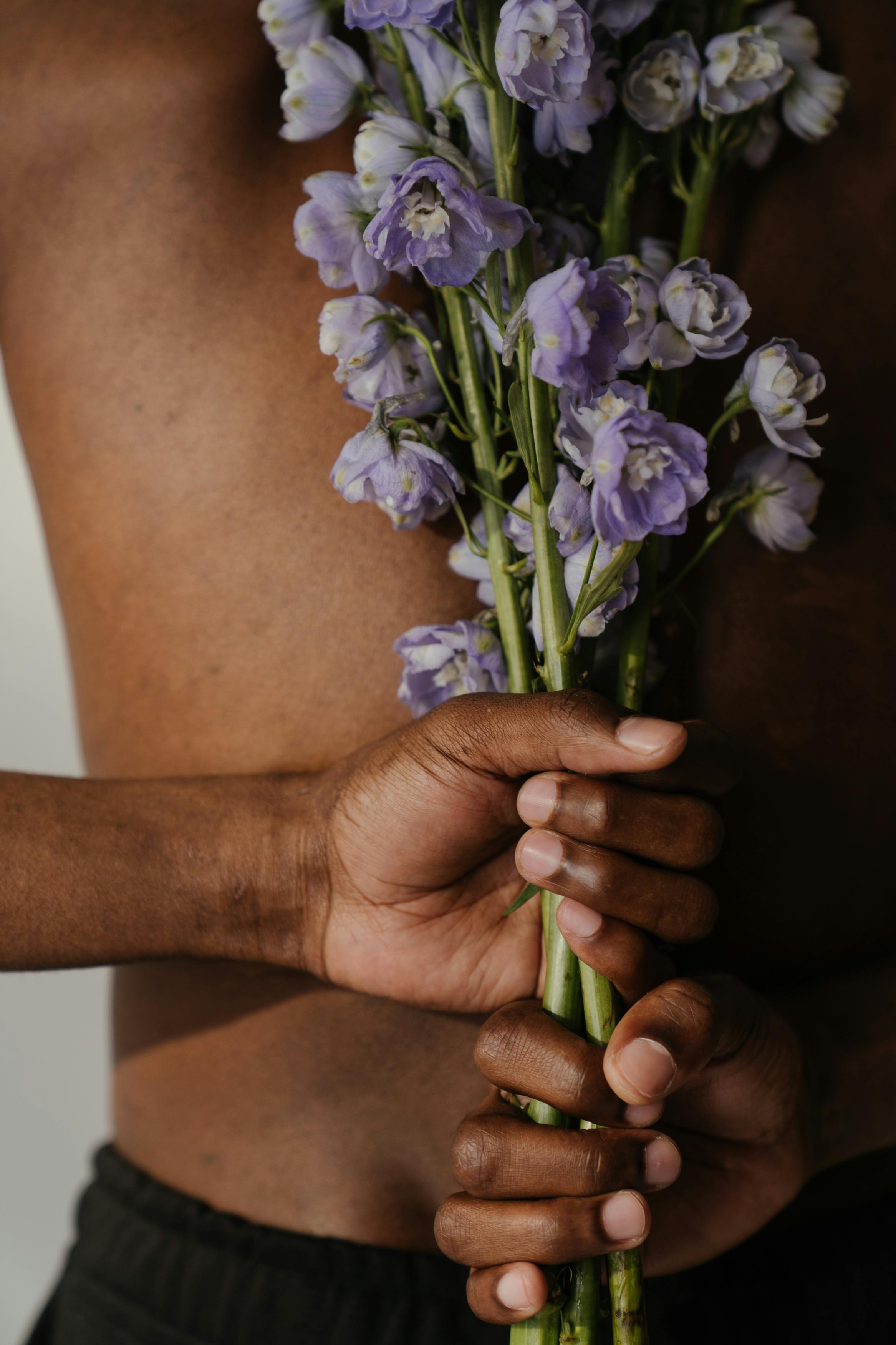 person holding purple flower bouquet