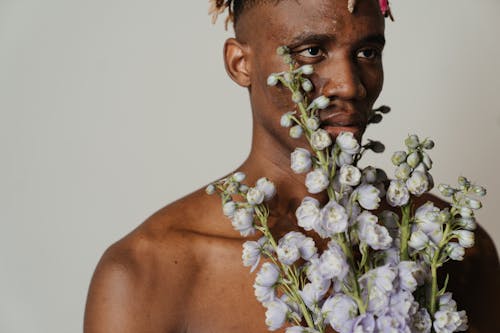 Topless Man With White Flower on His Mouth