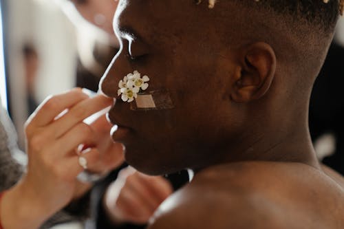 Man in Black Shirt With White Flower on Ear