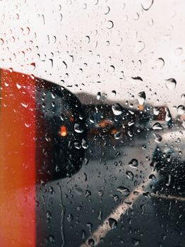雨滴模糊了透过玻璃窗看到的城市景观，营造出一种喜怒无常的氛围