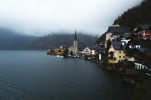 Free White and Brown Concrete Building Beside Body of Water Stock Photo