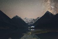 在宁静的山间湖泊和山峰之上，银河系笼罩着雄伟的夜空