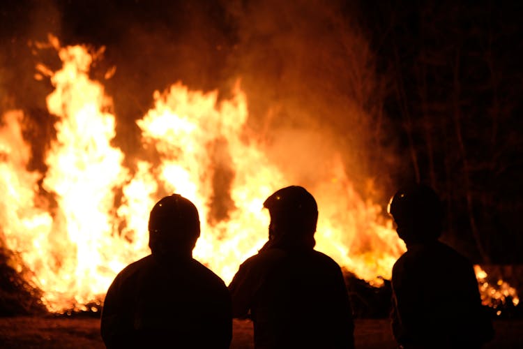 Silhouette Of Firefighters Near The Blazing Fire