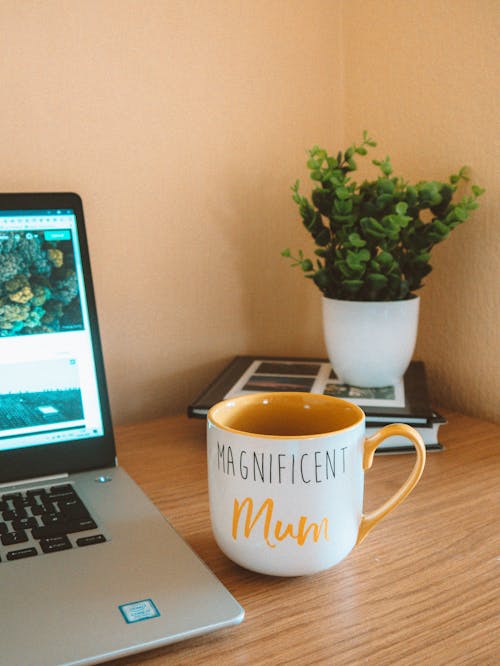 White Ceramic Mug Beside Laptop