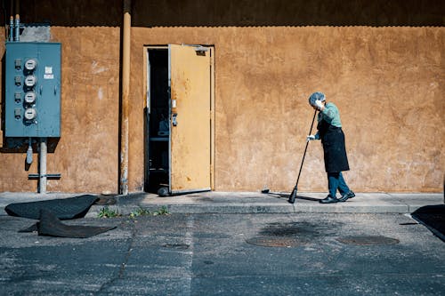 Free Photo of Person Sweeping the Sidewalk Stock Photo