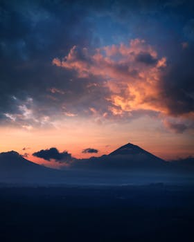 Majestic sunrise over Mount Agung in Bali with vibrant sky colors and dramatic clouds.