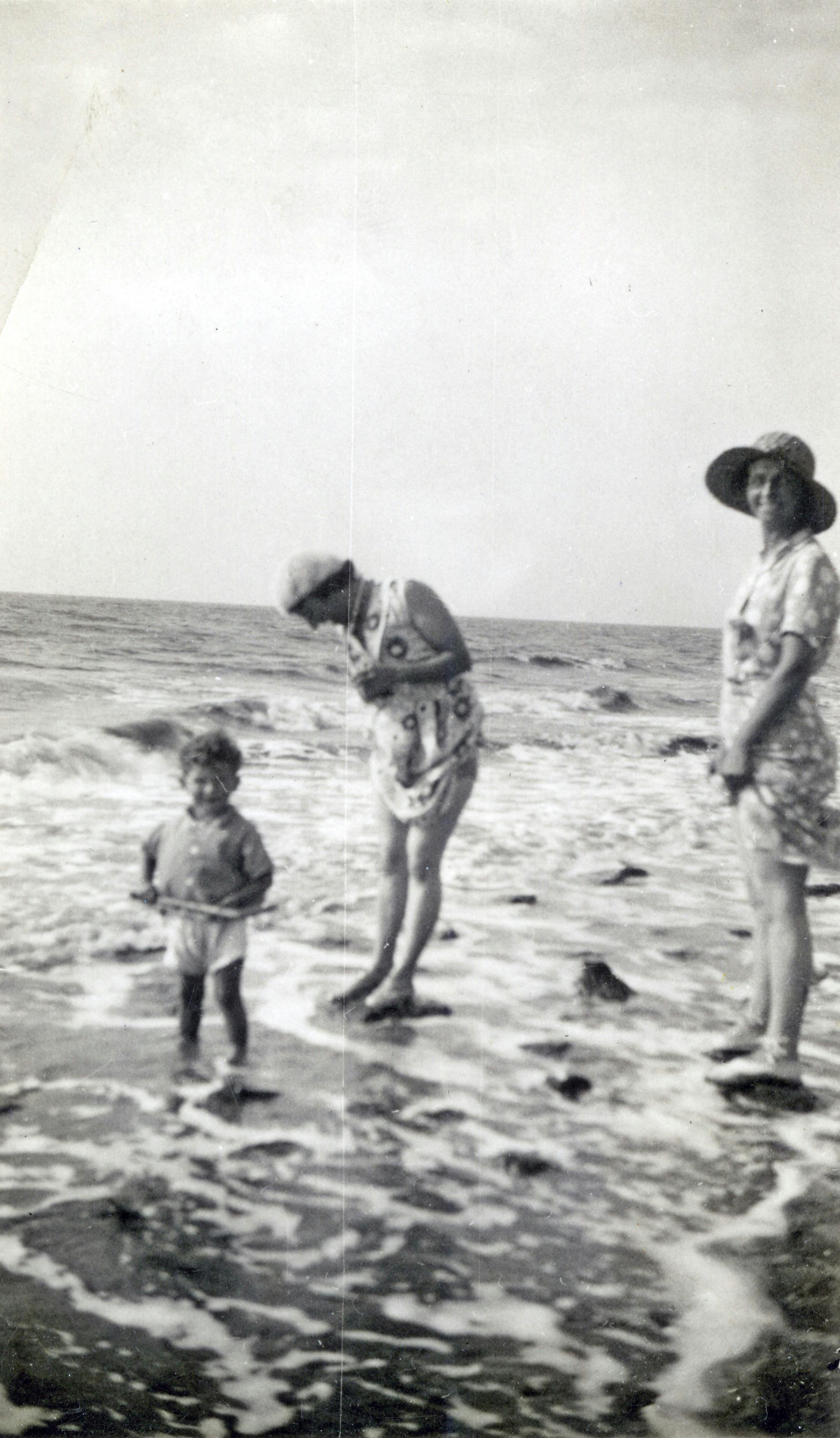 Nostalgic beach scene capturing family bonding in classic black and white.