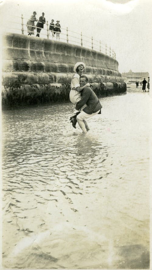 Monochrome Photo of Man Carrying a Woman