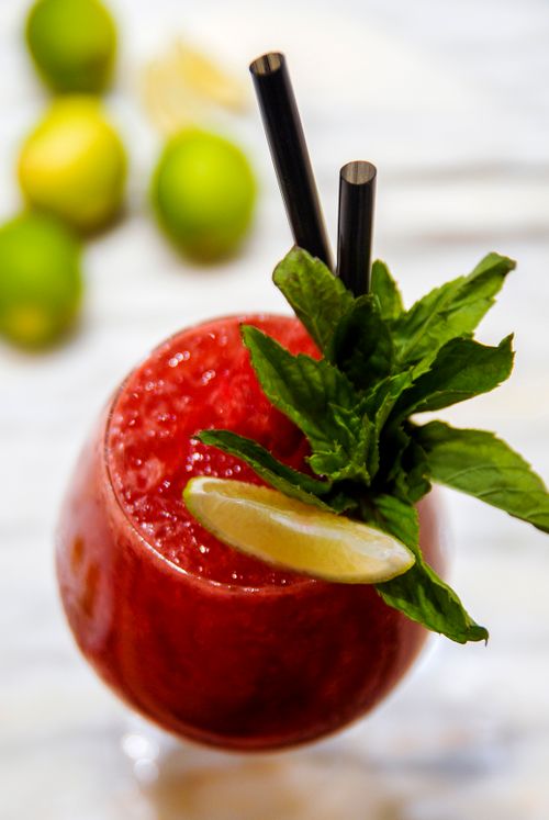 Free A vibrant red berry cocktail with lime and mint garnish, perfect for summer refreshment. Stock Photo
