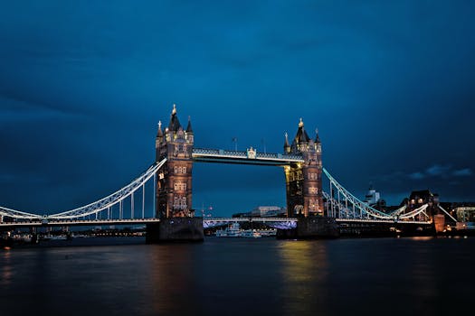 A stunning view of the illuminated Tower Bridge in London against a deep blue night sky. by Chris Schippers