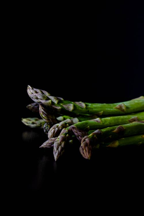 Free Close-up of fresh green asparagus spears on a black background. Stock Photo