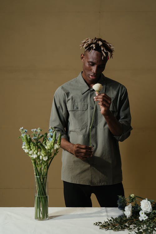 Man in Gray Dress Shirt Holding White Rose